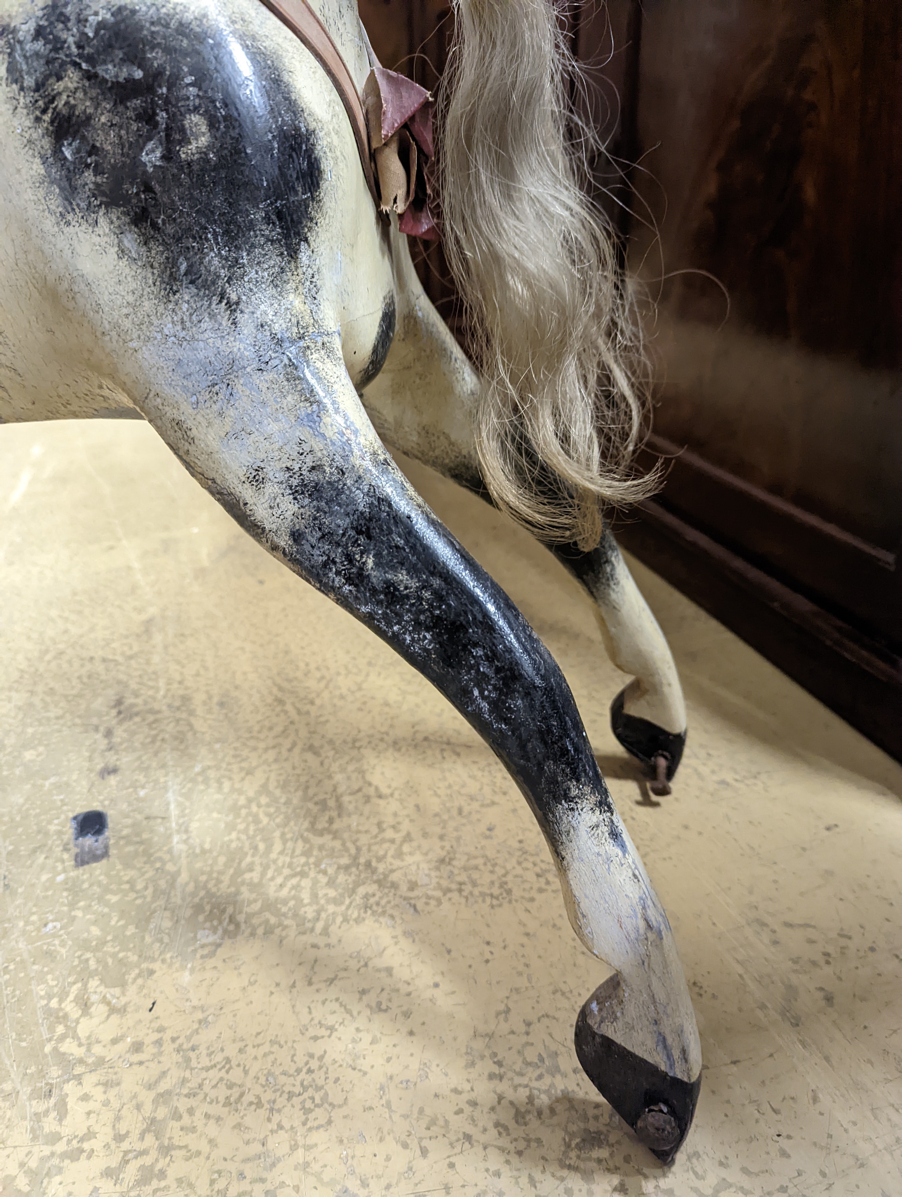 A Victorian carved and painted wood rocking horse, lacking underframe, length 77cm and two painted wood hobby horses, 58cm and 38cm